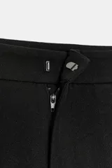 Pantalón de tiro medio con pinzas delanteras, bolsillos laterales y falsos bolsillos de vivo en la parte trasera. Presenta un corte holgado que se estrecha hacia el tobillo, con bajo acabado en pliegues y cierre frontal con cremallera, botón interior y gancho.