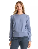 Buzo de tejido de punto gris, con cuello redondo, mangas largas con diseño de rombos calados y detalle de volado en los puños. Presenta hombros ligeramente fruncidos y terminaciones en rib acanalado.
