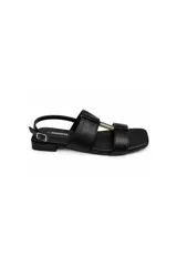 Sandalia de taco bajo Paddock modelo Paros, color negro, con tiras anchas, pulsera regulable con hebilla lateral y detalle metálico en el centro.