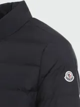 Campera puffer Moncler modelo Baudinet, color negro, con cuello alto, cierre frontal completo y diseño acolchado horizontal.
