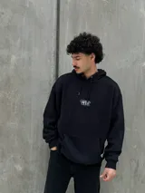 Canguro negro con capucha ajustable con cordones, bolsillo tipo canguro y logo "Osten Club" estampado en el pecho. Corte oversize.