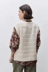 Chaleco tejido azul de calce relajado, silueta recta, cuello redondo, hombros caídos y diseño de punto con textura calada.