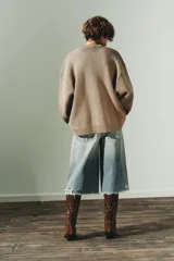 Jersey de punto liso con diseño oversize, cuello redondo y manga larga con puños acanalados.