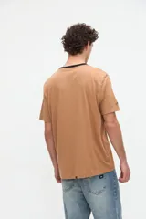 Remera blanca de algodón con textura suave, corte relaxed, manga corta, cuello redondo en contraste de color celeste y un bolsillo aplicado en el pecho.