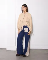 Pantalon de pana azul marino con corte semi oxford, presenta paneles laterales y bolsillos frontales con estampado floral en tonos beige.
