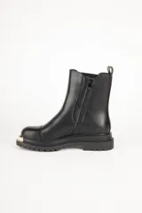 Bota Chelsea de cuero sintético color negro, con elástico lateral y aplique metálico dorado en la puntera.