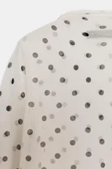 Top de punto fino semitransparente con cuello subido y manga larga, con estampado de lunares.