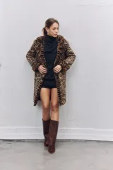 Tapado de piel sintética con estampado animal print de leopardo, corte recto y largo hasta la rodilla, con solapas clásicas y cierre frontal.