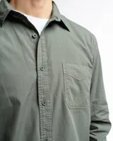 Camisa de manga larga color gris oscuro, confeccionada en algodón, con cuello clásico, cierre frontal con botones, bolsillo de parche en el pecho y corte clásico.