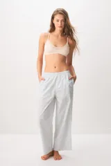 Pantalón largo tipo pijama de algodón, con diseño a rayas celestes y sutiles detalles de puntos rojos, corte recto y bolsillos laterales.