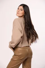 Buzo tejido de punto color beige, con cuello redondo, mangas largas con puños ajustados y diseño de corte cropped.