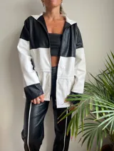Campera con capucha, de cuero sintético, con diseño color block en blanco y negro y cierre frontal.