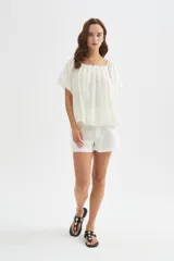 Blusa holgada de lyocell color blanco, con diseño plisado, escote cuadrado y mangas cortas abullonadas.