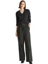 Sweater de punto Tommy Hilfiger con cuello en V y manga larga. Presenta un diseño liso en color negro con el logo de la marca bordado en el pecho.