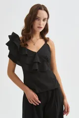 Blusa negra de poliéster con cuello en V, tirantes anchos y un diseño asimétrico con volados escalonados en un hombro. Corte entallado.