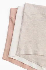 Pack de tres bombachas tipo shortie de algodón, tiro alto, con piernas de corte bajo y refuerzo interior. Los colores son beige melange, blanco y rosado pálido.