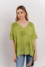 Blusa verde lima de algodón, con escote en V, mangas cortas y holgadas. Presenta estrellas bordadas en relieve y un detalle de lentejuelas en el dobladillo inferior.