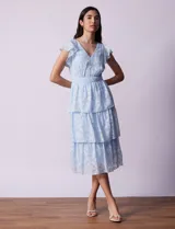 Vestido midi celeste de gasa estampada, marca Julia Jordan. Tiene escote en V, mangas cortas con volados y forro interno a tono.