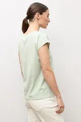Remera blanca de manga corta, con cuello en V decorado con detalles de vainillas.