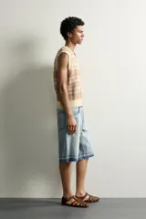 Chaleco relaxed fit de punto tejido en hilatura de algodón, con diseño a cuadros en tonos marrón y beige, cuello en V y acabados en rib en el cuello, las sisas y el ruedo.