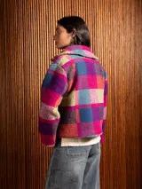 Chaquetón corto de lana con diseño de cuadros en tonos tierra y borravino, con solapas amplias y cierre frontal de botones.