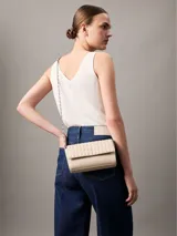 Cartera tipo sobre o clutch de Calvin Klein, color beige claro, con diseño acolchado de rombos en la solapa y cuerpo liso. Posee correa de cadena metálica plateada y logo metálico grabado en la parte frontal.