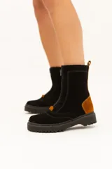 Bota de caña media de cuero color negro con detalles en marrón y suela track.