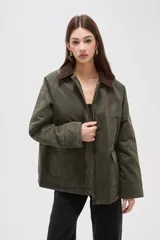 Campera de algodón estilo field jacket en color verde oliva, con cuello de pana en contraste color marrón, cierre frontal oculto y bolsillos delanteros amplios.