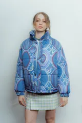 Campera puffer azul con estampado de motivos geométricos y figuras como estrellas de mar y sirenas.