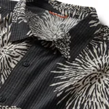 Camisa de manga corta gris oscuro con estampado de flores blancas.