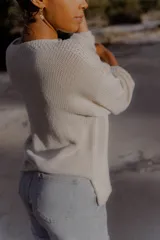Sweater túnica oversize color crudo, tejido artesanalmente en Uruguay con hilado serido 50% algodón y 50% acrílico. Presenta escote bote con trama diferenciada, terminación especial en mangas y tajos laterales.
