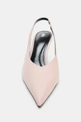 Zapato de tacón destalonado color rosado, con diseño de punta fina, escote en V y tira trasera elástica. Cuenta con tacón alto y fino.