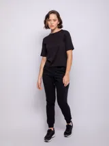 Pantalón tipo babucha de corte deportivo, color beige, con cintura elástica ajustable mediante cordón, puños en los tobillos y bolsillos frontales.