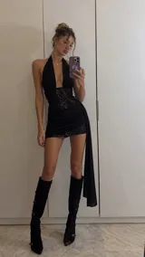 Vestido corto de lentejuelas con base de microfibra, escote halter pronunciado, espalda descubierta y detalle de tela drapeada en la cintura con caída lateral.