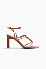 Sandalias de taco alto con punta cuadrada y tiras finas entrelazadas con detalle de nudo en el empeine. Cuenta con una pulsera ajustable con hebilla en el tobillo.