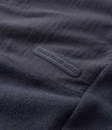 Buzo de fleece color verde agua con capucha ajustable, cierre frontal completo y bolsillo con cierre en el pecho. Presenta un diseño funcional con recortes en tejido plano y calce regular.