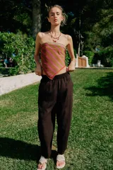 Pantalón de lino marrón oscuro, de corte barrel con pernera holgada que se estrecha hacia el tobillo, cintura elástica y bolsillos delanteros.