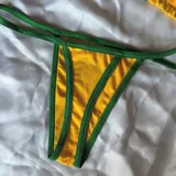 Conjunto de bikini amarillo con detalles y tiras verdes, compuesto por un corpiño triangular y una bombacha colaless con el texto "Brasil" y la bandera bordados en el frente.