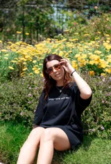 Remerón negro de corte amplio con estampa de flor blanca en la espalda.