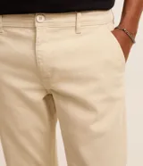 Pantalón masculino de corte skinny confeccionado en sarga de algodón con elastano. Presenta cierre frontal con botón y cremallera, cintura con trabillas y bolsillos laterales y traseros.