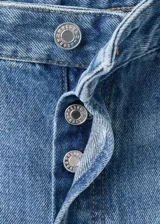Jeans de tiro medio en denim azul con lavado medio, corte recto y amplio, diseño clásico de cinco bolsillos y cierre frontal con botón y cremallera.
