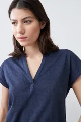 Remera de manga corta con escote en V y detalle de cartera frontal, confeccionada en tejido de punto con textura jaspeada.
