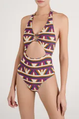 Malla enteriza con estampado geométrico multicolor en tonos beige, fucsia, verde y naranja. Presenta diseño halter con argolla central de madera y abertura frontal en la cintura.