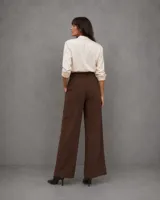 Pantalon de vestir color marron, de corte recto y tiro alto, con cintura estructurada y cierre frontal. Presenta una silueta amplia y fluida.
