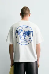 Camiseta de corte relajado con cuello redondo y manga corta. Presenta un diseño con estampados en tono azul con efecto lavado en la parte frontal.