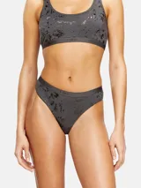 Tanga de algodón elástico gris oscuro con efecto metalizado y estampa sutil tipo foil, con banda elástica en la cintura con el logo de la marca.