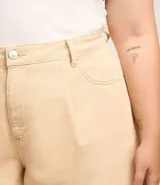 Short color beige de corte evasé, con cintura alta, bolsillos delanteros y traseros, trabillas en la cintura y bajo deshilachado.
