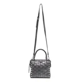 Cartera tipo baúl pequeña de cuero negro, con cuerpo tejido en patrón de cuadros (intrecciato) y tachas metálicas redondas en los bordes. Posee doble asa superior y correa ajustable para llevar al hombro o cruzada.