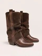 Botas de caña media confeccionadas en cuero, con diseño de doble textura que combina cuero liso en la puntera y gamuza en la caña. Presentan una franja vertical decorativa con tachas metálicas y taco cuadrado bajo.