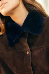 Camisa de cuero marrón con cuello y solapas de corderito sintético, mangas largas y cierre frontal con broches.